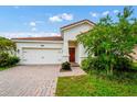 Home with brick driveway, two car garage, and a clay tile roof at 1415 Oak Marsh St, Davenport, FL 33837