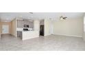 Open-concept living space with tile floors, gray cabinetry, and stainless steel appliances at 1415 Oak Marsh St, Davenport, FL 33837