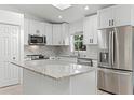 Bright and modern kitchen featuring stainless steel appliances, white cabinets, and an island with granite countertops at 1475 James St, New Smyrna Beach, FL 32168