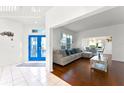 Bright living room with hardwood floors, neutral-toned sofa, and a striking blue front door at 219 Strathmore Cir, Kissimmee, FL 34744