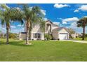 Gorgeous home with lush green lawn and mature palms at 2315 Anhinga Dr, Kissimmee, FL 34743