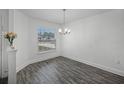 Bright dining room features wood floors, modern chandelier, and sunlit window view at 236 Elm Ct, Kissimmee, FL 34759