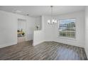 Bright dining area with wood-look floors, modern chandelier, and natural light at 236 Elm Ct, Kissimmee, FL 34759