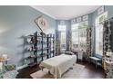 Relaxing bedroom with massage table, hardwood floors, natural light, and custom shelving at 243 Sagecrest Dr, Ocoee, FL 34761