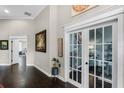 Inviting hallway with hardwood floors, white trim, and french doors leading to another room at 243 Sagecrest Dr, Ocoee, FL 34761