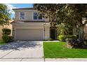 Charming two-story home features a well-maintained lawn and an attached two-car garage at 2509 Archfeld Blvd, Kissimmee, FL 34746