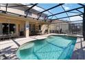 Relaxing screened-in pool area with dining set and connected spa; perfect for entertaining at 2509 Archfeld Blvd, Kissimmee, FL 34746