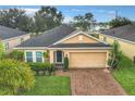 Charming one-story home with a brick driveway, well-maintained landscaping, and an attached two-car garage at 254 Andalusia Loop, Davenport, FL 33837