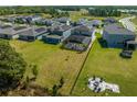 Aerial view of spacious backyard with fire pit and view of the neighborhood, lake, and solar panels at 2613 Camden Park Loop, Davenport, FL 33837