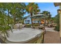 Relaxing hot tub on a brick patio surrounded by lush greenery, ideal for unwinding at 3083 Key Lime Loop, Kissimmee, FL 34747
