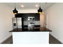 Modern kitchen with black countertops, stainless appliances, and pendant lighting at 3259 Energy Dr, Kissimmee, FL 34747