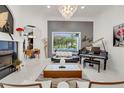 Bright living room featuring modern decor, fireplace, grand piano, and a view of the outdoor pool at 3382 Fernlake Pl, Longwood, FL 32779