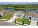Stunning aerial view of a home near a picturesque lake with a walking path and lush surroundings at 4307 Pebbles Throw Dr, Kissimmee, FL 34746