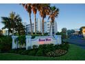 Scenic view of the Ocean Walk entrance sign with landscaping, palm trees, and building at 5300 S Atlantic Ave # 4-302, New Smyrna Beach, FL 32169