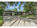 Charming single-story home featuring mature trees, a well-kept lawn, and an attached two-car garage at 605 Ensenada Dr, Orlando, FL 32825