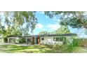 Charming single-story home with a well-maintained lawn, mature trees, and inviting front entrance at 605 Ensenada Dr, Orlando, FL 32825