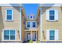 Townhouses with light yellow siding and white trim featuring a charming entrance at 7595 Sunny Dreams Ln, Kissimmee, FL 34747