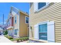 Two-story townhomes with light yellow siding, white trim, and a well-maintained lawn at 7595 Sunny Dreams Ln, Kissimmee, FL 34747
