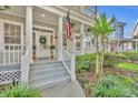 Attractive front porch featuring white columns, potted plants, and a decorative wreath on the front door at 821 Veranda Pl, Celebration, FL 34747