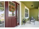 Charming front porch with cozy seating and a decorative wreath on the front door creates a warm welcome at 8643 Coventry Park Way, Windermere, FL 34786