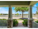 Enjoy a serene view of the lake from the front porch with stone pillars and a manicured landscape at 8643 Coventry Park Way, Windermere, FL 34786