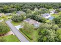 A high angle aerial view of a home with pool in wooded community surrounded by green lawns at 89 Pine Forest Ln, Haines City, FL 33844