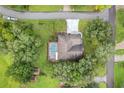 Aerial view of home with a screened pool, surrounded by lush greenery and mature trees, offering privacy at 89 Pine Forest Ln, Haines City, FL 33844