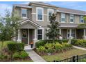 Stylish two-story townhome featuring a welcoming front porch and tidy, green landscaping at 9433 Randal Park Blvd, Orlando, FL 32832
