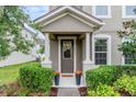 Inviting front porch with decorative flowerpots flanking the door and lush greenery at 9433 Randal Park Blvd, Orlando, FL 32832