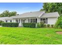 Charming single-story home featuring a lush green lawn and mature landscaping at 25929 Newcombe Cir, Leesburg, FL 34748