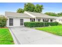Well-maintained single-story home with charming curb appeal and a decorative driveway at 25929 Newcombe Cir, Leesburg, FL 34748