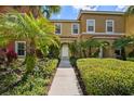 Inviting two-story townhome with lush landscaping and a welcoming walkway leading to the front door at 3045 Yellow Lantana Ln, Kissimmee, FL 34747