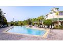 Inviting community pool area with lounge chairs and scenic lake views at 9051 Treasure Trove Ln # 405, Kissimmee, FL 34747
