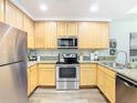 Well-lit kitchen with stainless steel appliances, ample countertop space, and light wood cabinetry at 9051 Treasure Trove Ln # 405, Kissimmee, FL 34747