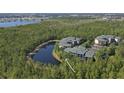 Scenic aerial view of condos nestled by a lake surrounded by lush greenery at 9061 Treasure Trove Ln # 104, Kissimmee, FL 34747