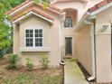 Inviting front exterior of a tan two-story home showcasing a tiled roof, window details, and a charming entrance at 5421 Watervista Dr, Orlando, FL 32821