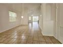 Bright living room featuring neutral tile flooring, a chandelier, and sliding doors to the outdoor area at 5421 Watervista Dr, Orlando, FL 32821