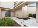 Beautiful front entryway featuring a charming door, beige siding, and lush tropical landscaping at 106 Madrid Dr, Casselberry, FL 32707