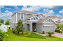 Exterior side view of a two-story house featuring a manicured lawn and a blue front door at 1317 Yorkdale Rd, Davenport, FL 33837