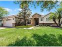 Attractive single-story home featuring stone accents, a two-car garage, and a lush front lawn at 972 Bighorn St, Oviedo, FL 32765