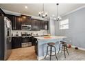 Modern kitchen featuring stainless steel appliances, dark cabinets, and a breakfast bar at 1350 Royal St George Blvd, Davenport, FL 33896