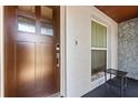 Elegant front door showcasing a dark wood finish with glass panels and a modern doorbell, complemented by textured walls at 1360 Springfield St, Kissimmee, FL 34744