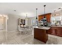 Open concept kitchen with an island, dark wood cabinets, granite countertops, stainless steel appliances, and adjacent dining area at 1360 Springfield St, Kissimmee, FL 34744
