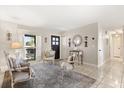 Inviting living room featuring neutral tones, stylish seating arrangements, decorative mirrors and tile flooring at 1360 Springfield St, Kissimmee, FL 34744