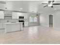 Bright open floor plan with white cabinets, stainless appliances, an island, and new floors at 1440 Lake Shore Dr, Casselberry, FL 32707