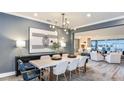 Modern dining room featuring contemporary chandelier, stylish furniture, and a view to living area at 15148 Willow Ridge Dr, Montverde, FL 34756