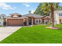 Attractive home with a well-maintained lawn, a two-car garage and a palm tree in the front yard at 18 Cooledge St, Winter Garden, FL 34787