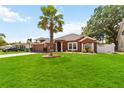 Charming home with a lush lawn, features a two-car garage and a stately palm tree at 18 Cooledge St, Winter Garden, FL 34787