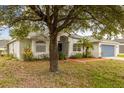 Lovely single-story home with arched entryway, mature landscaping, and a well-manicured lawn at 201 Churchill Ct, Kissimmee, FL 34758