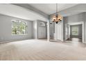 Spacious living room featuring carpet flooring, arched doorways, chandelier, and natural light at 201 Churchill Ct, Kissimmee, FL 34758